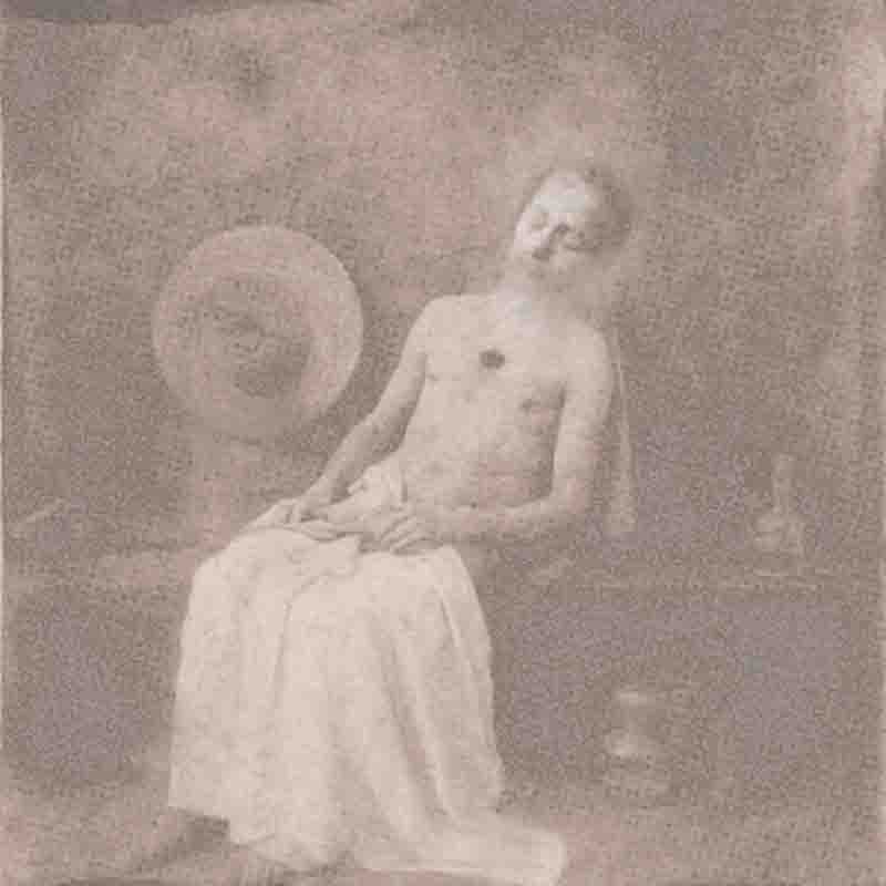 Vintage photograph of a bare-chested man (Hippolyte Bayard) wrapped in a cloth sitting on a bench that evokes a sense of stillness.