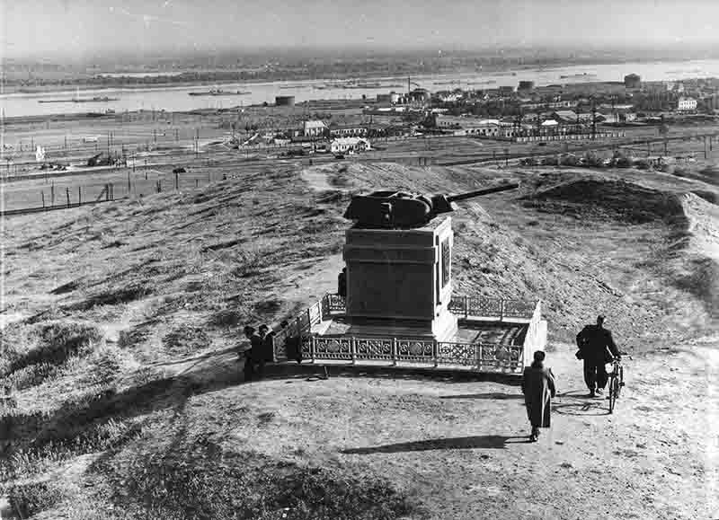 A black and white image depicting a tank turret atop Mamayev Hill in Stalingrad (today Volgograd), surrounded by a serene landscape.